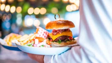 A person holding a plate with a burger and fries.