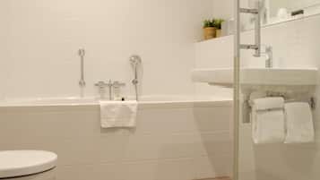 Ein modernes Badezimmer mit einer weißen Badewanne, einer Duschkabine aus Glas und einem weißen Waschbecken.
