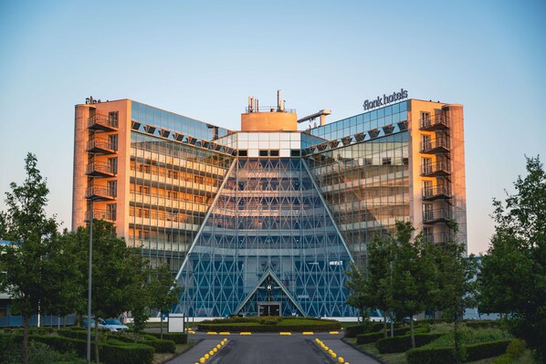 A modern hotel with a distinctive triangular glass facade and a central atrium. - Flonk Hotel Groningen Zuid, BW Signature Collection (Groningen)