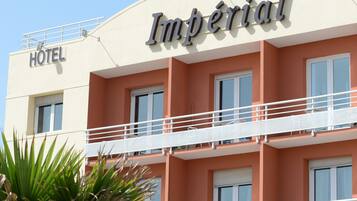 Ett hotell som heter ”Imperial” med en vit fasad och balkonger.