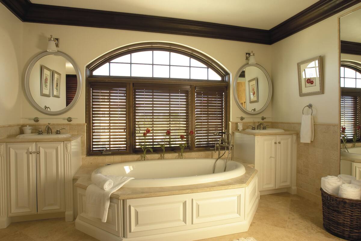 Une salle de bain spacieuse avec une grande baignoire sur pieds, deux lavabos et un grand miroir au-dessus de la baignoire.