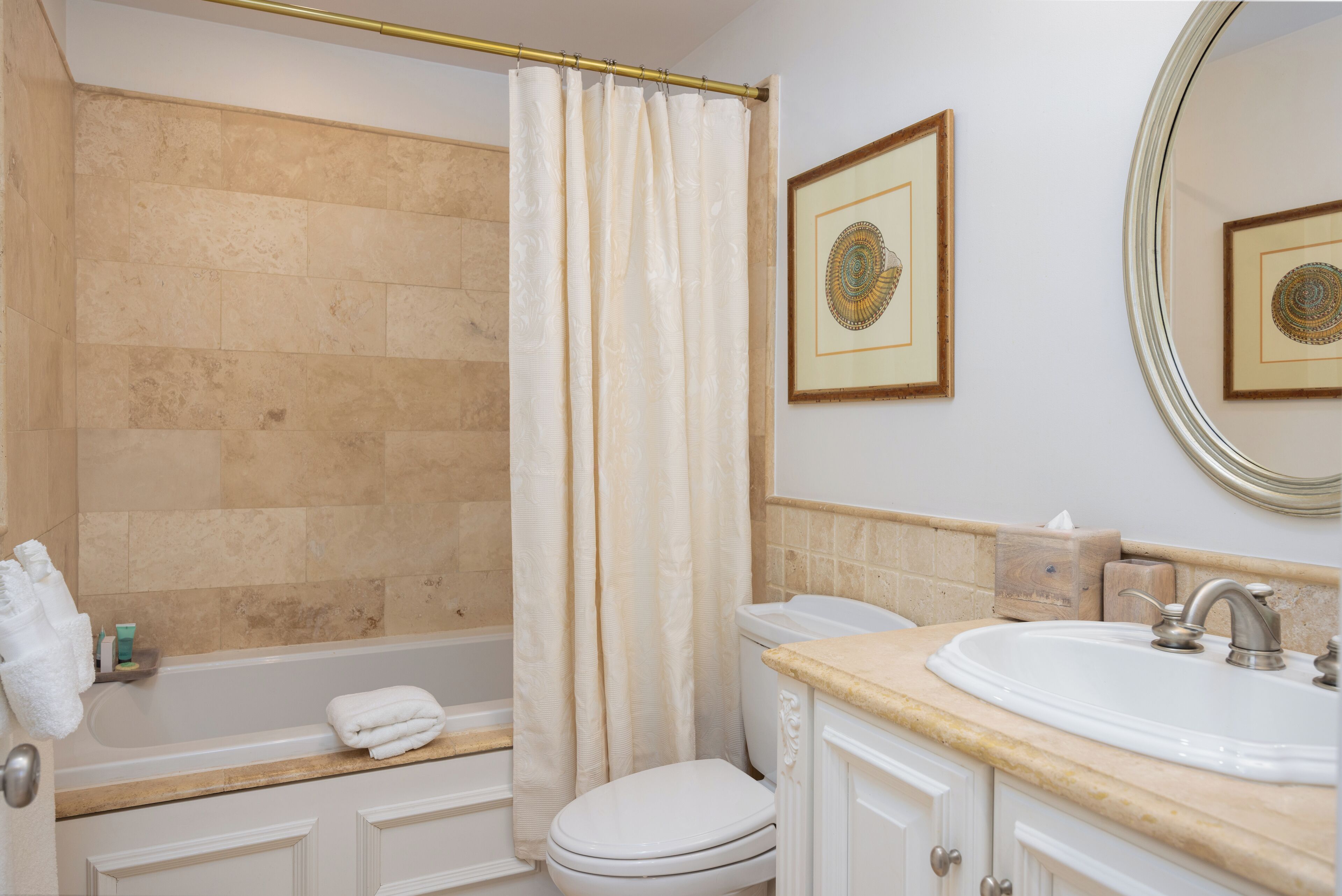 Een badkamer met een bad, toilet, wastafel en douchegordijn.