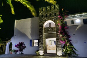 A stone building with a white facade, an arched entrance, and a sign reading "Pyrgaki Hotel". - Pyrgaki Hotel (Paros)