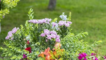 A wicker basket filled with colorful flowers on a stone ledge.
