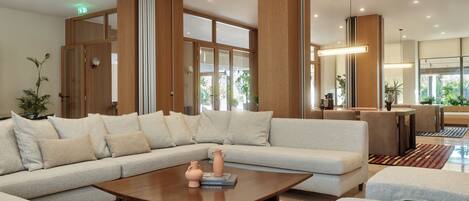 Una sala moderna con un sofá modular, una mesa de centro de madera y un comedor con mesa y sillas.
