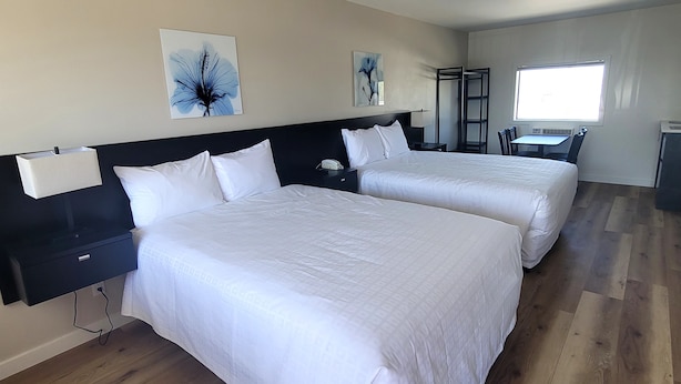 A hotel room with two beds, a desk, and a window. - Richland Inn and Suites (Richland)