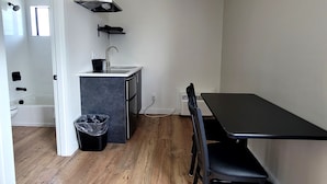 A compact kitchen with a sink, stove, and a small window. - Richland Inn and Suites (Richland)