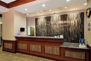 A reception desk with a marble-like wall, a clock, and a framed picture. - Residence Inn by Marriott DFW Airport North/Grapevine (Grapevine)
