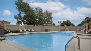 A swimming pool with lounge chairs and a stone wall. - Residence Inn by Marriott DFW Airport North/Grapevine (Grapevine)