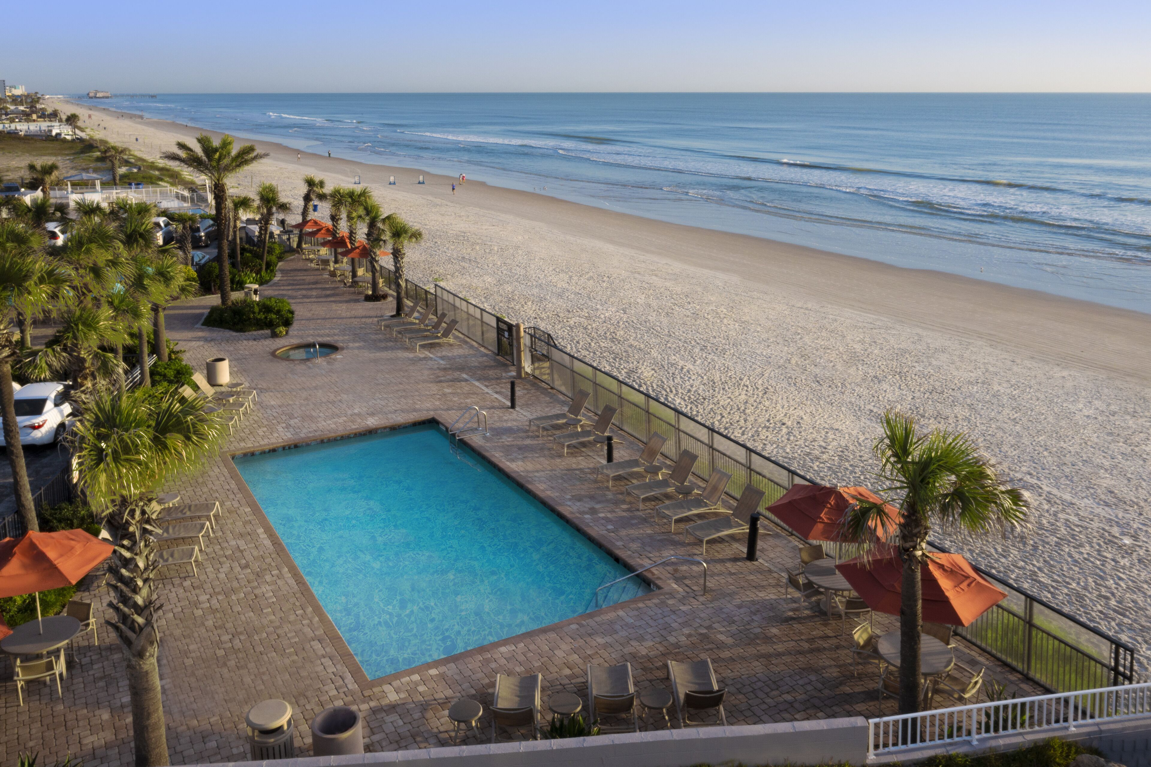 Zona de piscina con vista a la playa y al océano.