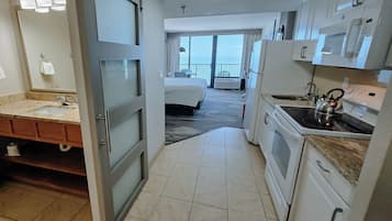 Ein Hotelzimmer mit Bad, Küchenzeile und einem Balkon mit Aussicht.