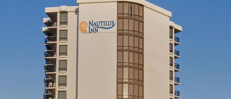 A tall, modern hotel with a prominent sign reading "Nautilus Inn."