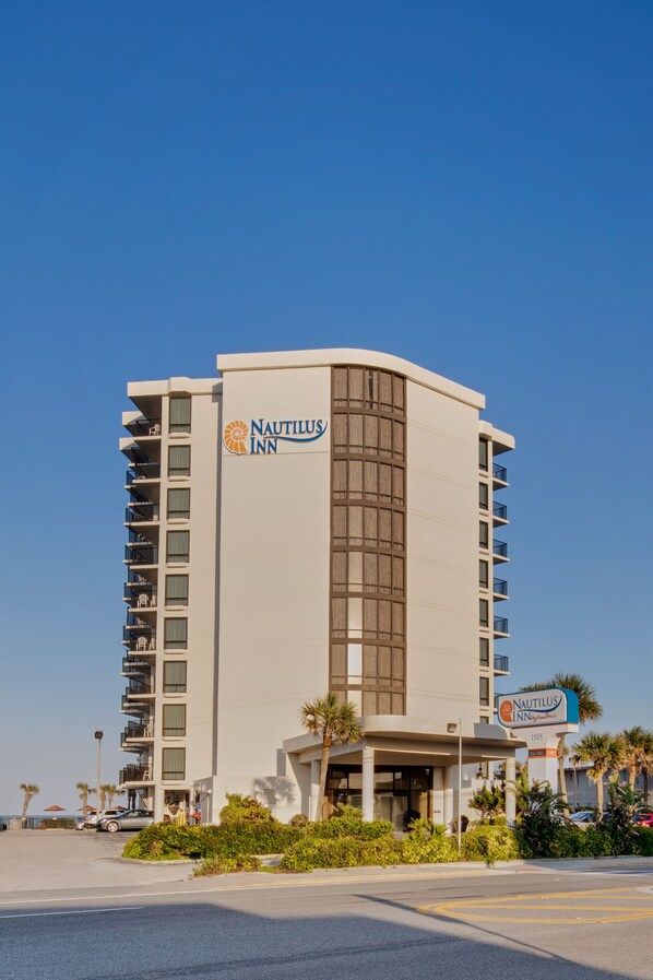 A tall, modern hotel with a prominent sign reading "Nautilus Inn."