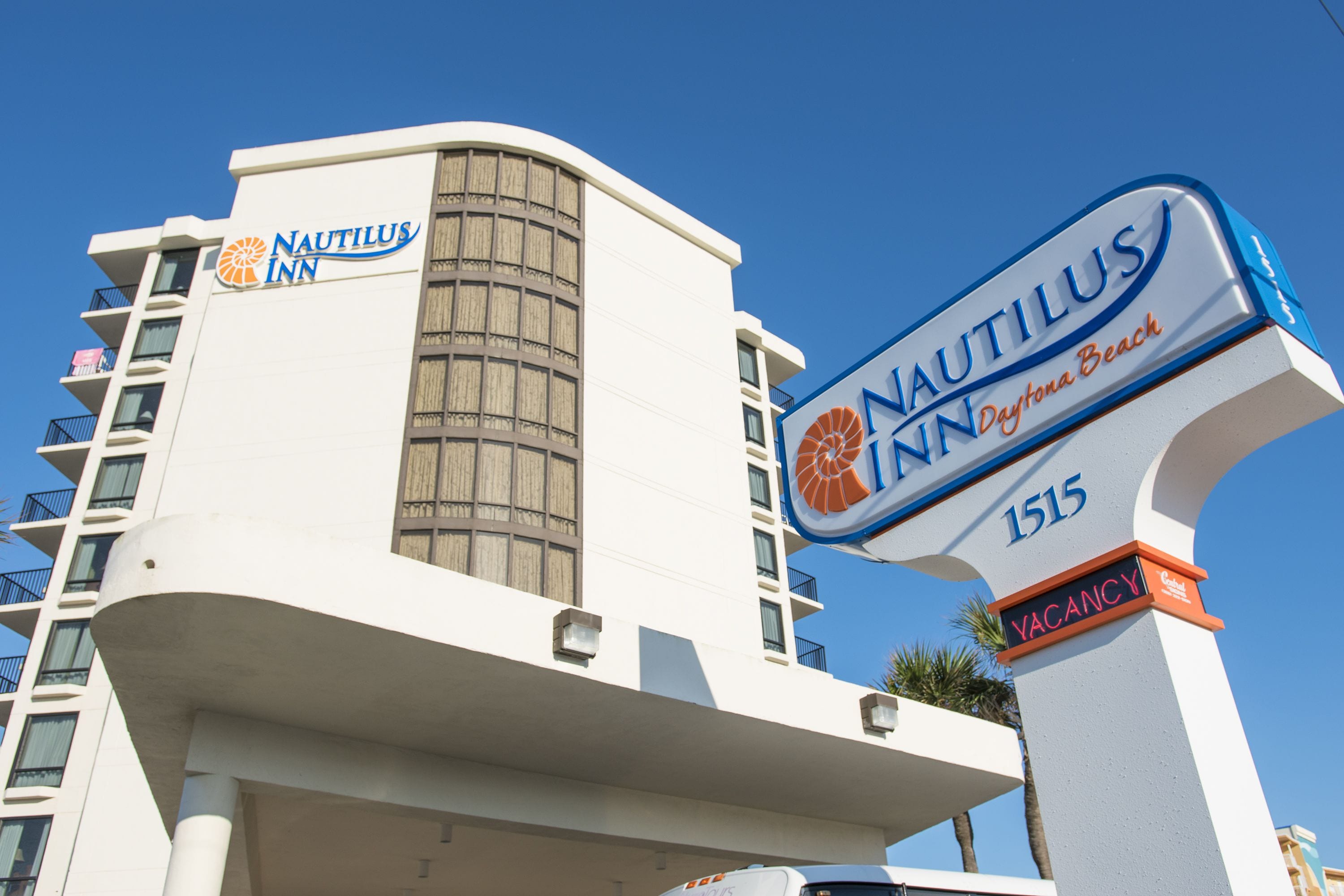 Un edificio con cartel de Nautilus Inn, de arquitectura moderna con fachada curva y balcones.