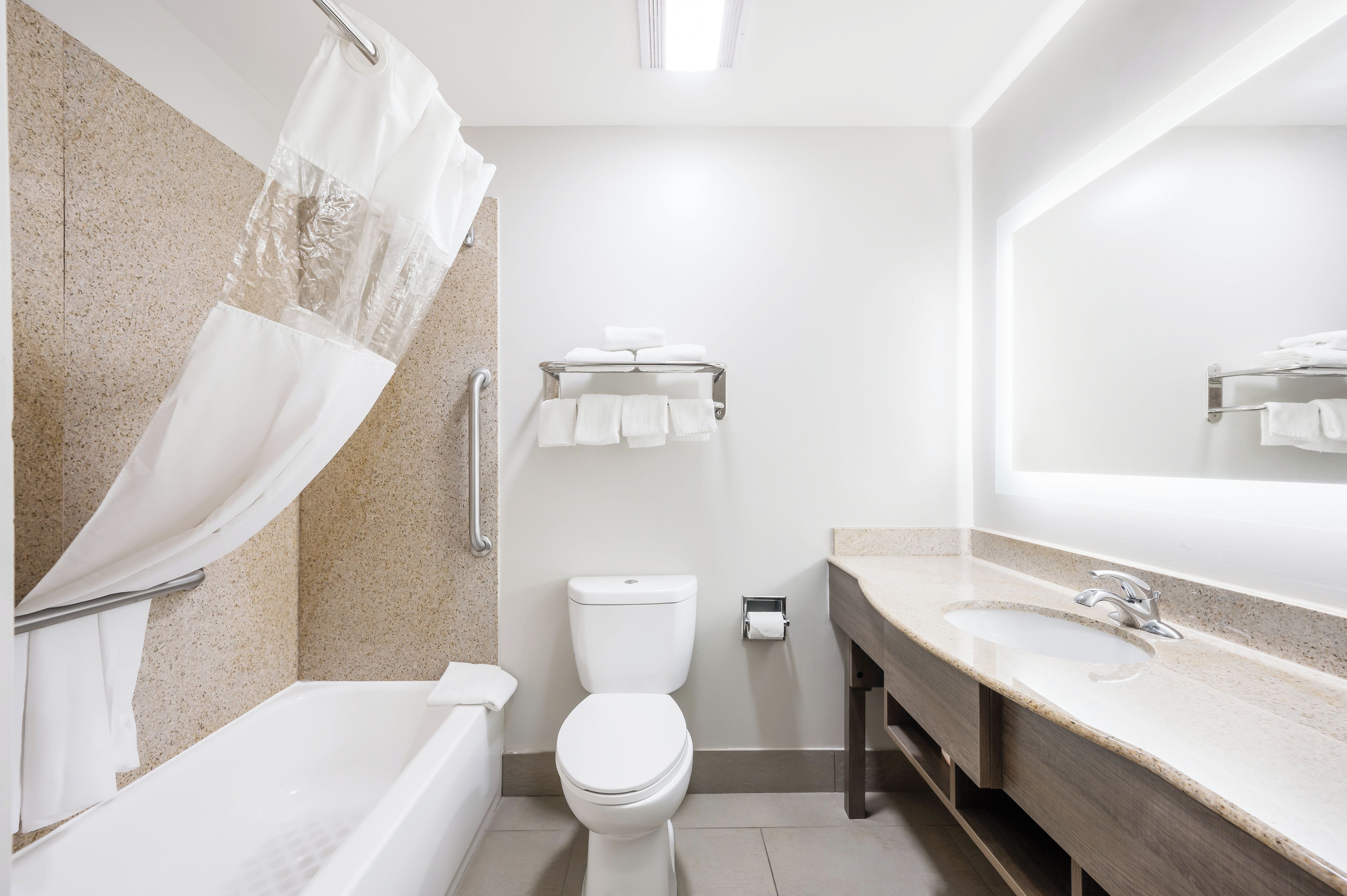 A modern bathroom with a bathtub, toilet, and sink.