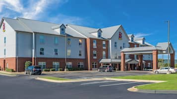 A multi-story hotel with a covered entrance and a parking lot.