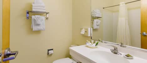 A bathroom with a white sink, a toilet, a towel rack, and a mirror.