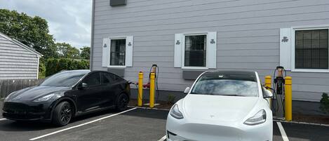 Dos autos estacionados en un estacionamiento, con un edificio al fondo.