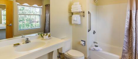 A bathroom with a sink, toilet, and shower.