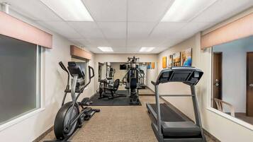 A fitness center with treadmills, elliptical machines, and weight equipment.