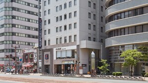 Un hôtel moderne, reconnaissable à son logo en forme de « C », à ses nombreux étages et à sa façade incurvée.