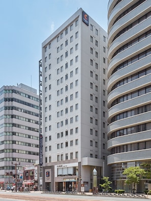 Ein modernes Hotel mit einem auffälligen 'C'-Logo, mehreren Etagen und einer geschwungenen Fassade.