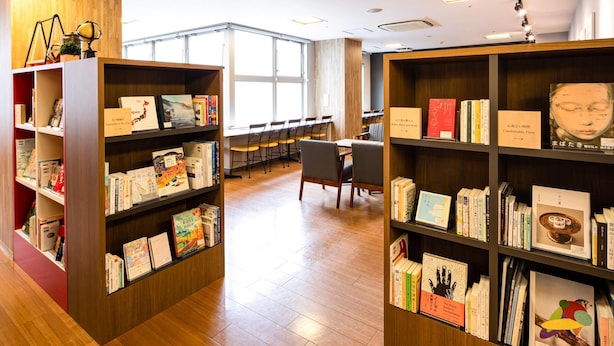 Una biblioteca con estanterías de madera, mesas de lectura y sillas.