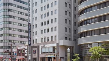 A multi-story hotel with a modern design, featuring a prominent entrance with a glass facade and signage for a hair salon.