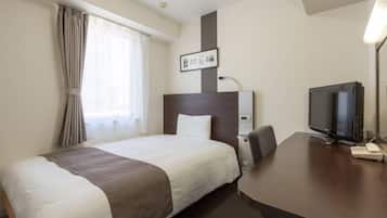 Una habitación de hotel con cama, escritorio, televisor y un cuadro en la pared.
