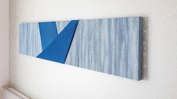 Obra de arte pendurada na parede, com formas geométricas e fundo texturizado.