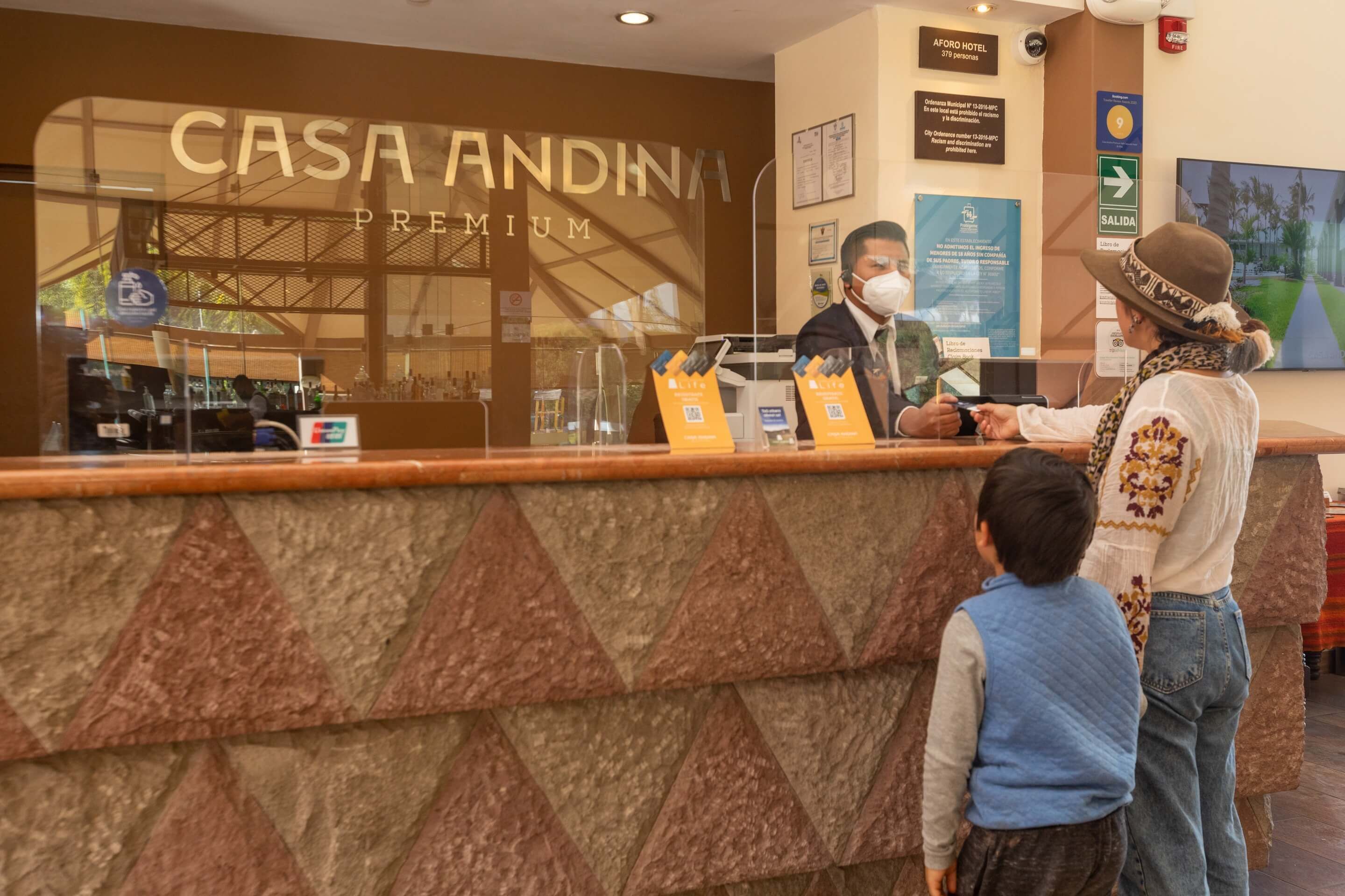 Een receptiebalie bij Casa Andina Premium met een goed zicht op het interieur, inclusief een ontvangstgedeelte, een balie en een muur met een bord.