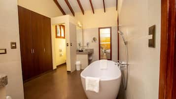 A modern bathroom with a freestanding bathtub, a vanity with a mirror, and a wooden wardrobe.