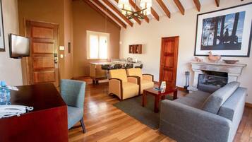 A living room with a wooden ceiling, a fireplace, and a dining area with chairs and a table.