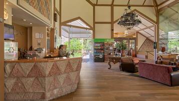 A spacious lobby with a reception desk, seating area, and a chandelier.
