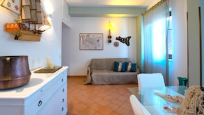 A living room with a sofa, a dining table, a ship model, and a map on the wall. - Palermo Mare Holidays (Palermo)