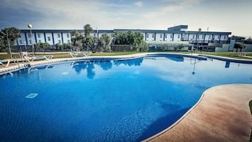 Una piscina al aire libre, tumbonas