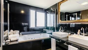 Uma casa de banho moderna com uma banheira grande, duas pias e um espelho amplo.
