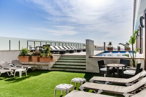 Una piscina al aire libre de temporada, sombrillas