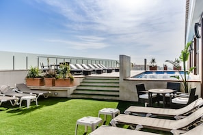 Una piscina al aire libre de temporada, sombrillas