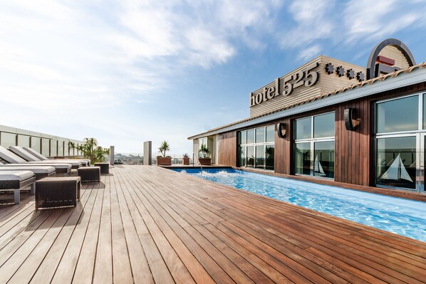 Una piscina al aire libre de temporada, sombrillas