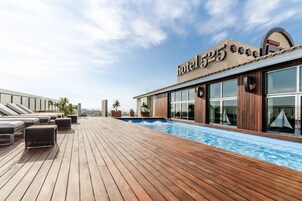 Una piscina al aire libre de temporada, sombrillas, tumbonas