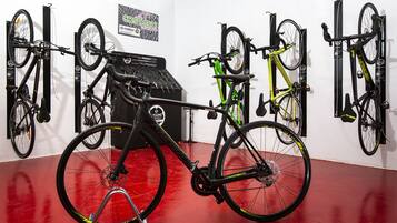 Una tienda de bicicletas con varias exhibidas en estantes colgantes.