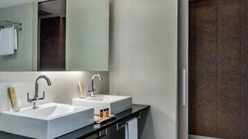 Une salle de bain moderne avec deux lavabos, un grand miroir et une douche à l’italienne.