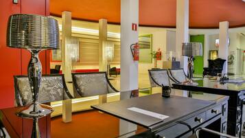 Un moderno vestíbulo de hotel con una zona de estar, un mostrador de recepción y un extintor.