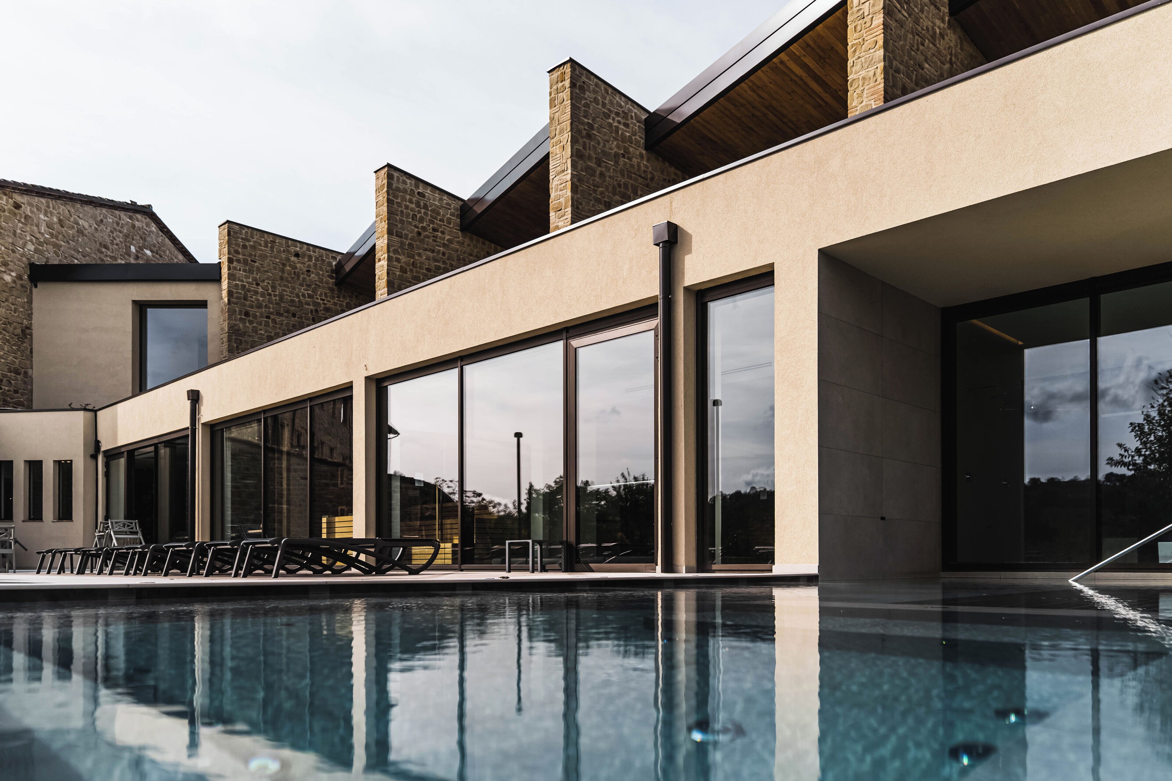Ein modernes Gebäude mit Pool, großen Fenstern und Außenbereich.