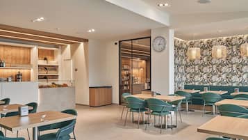A modern restaurant with a bar area, seating, and a decorative wall.
