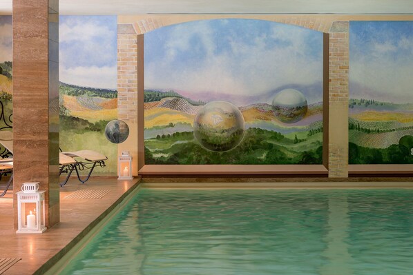 A pool area with a mural of a landscape and two spherical objects. - Borgo Lanciano Resort & Spa (Castelraimondo)