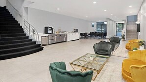 Ein modernes Interieur mit Treppe, Küchenbereich, Essplatz und Sitzgelegenheiten.