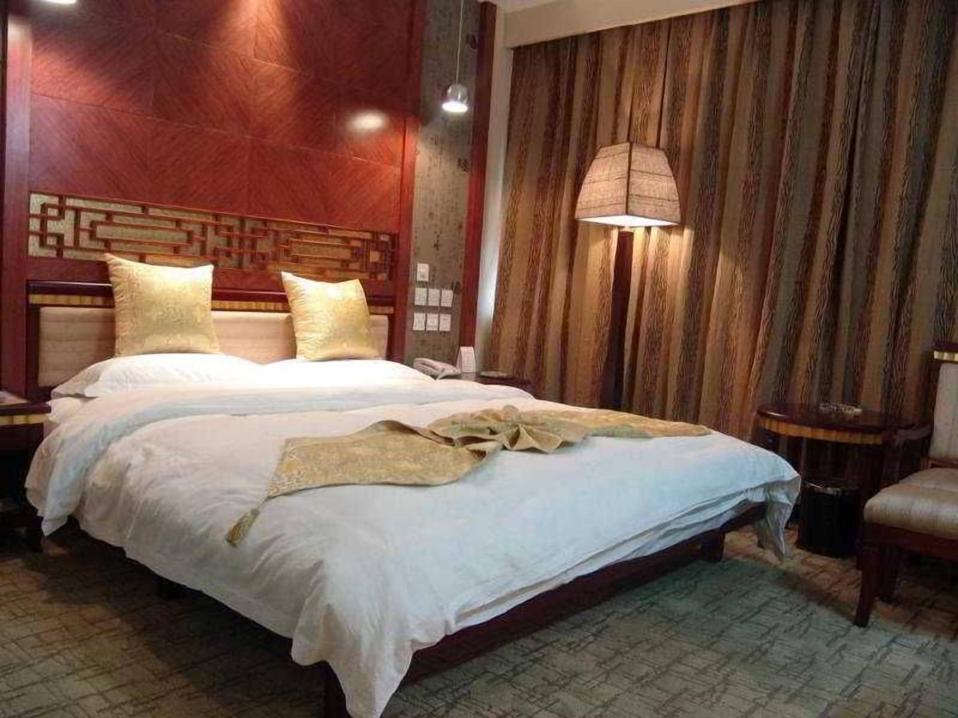 A double bed with a headboard, a bedside table, and a lamp.