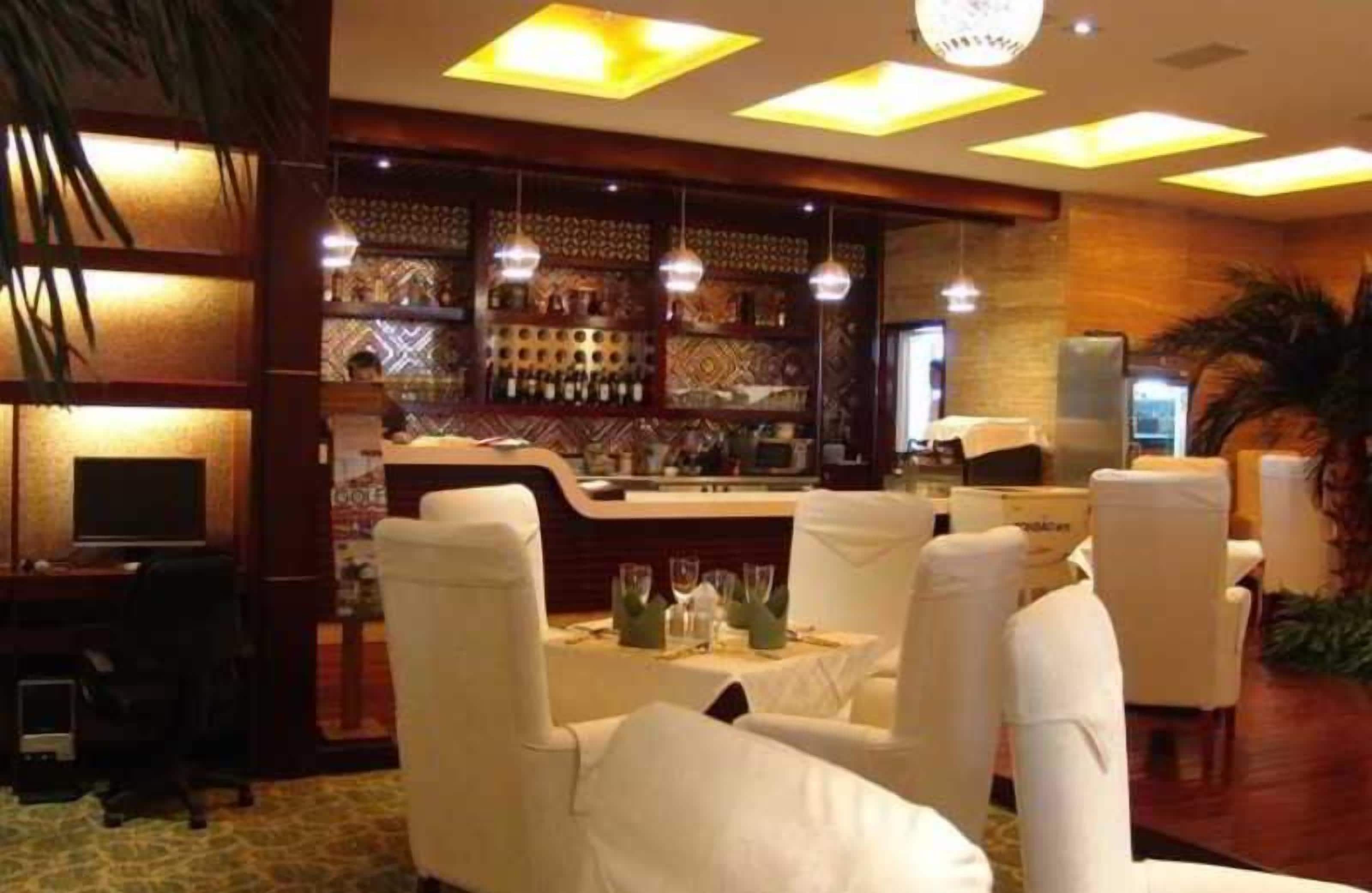 A bar area with a counter, bar stools, and a seating area with tables and chairs.